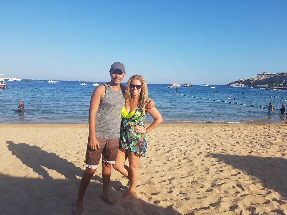 Two people standing on beach at Naama Bay Egpt with calm blue water in background. What to do in Sharm El Sheikh