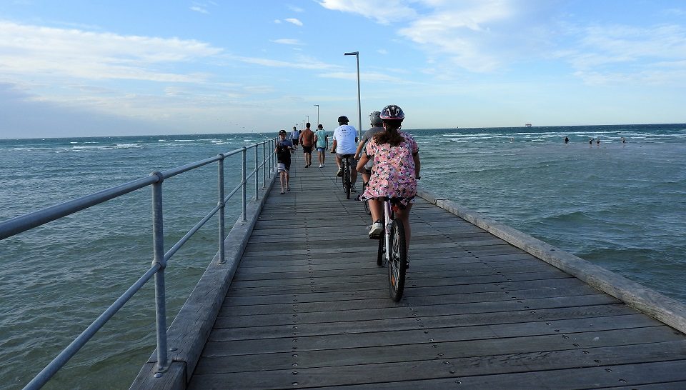 looking down the Rosebud pier with bike riders in front -Mornington Peninsula Day Trip