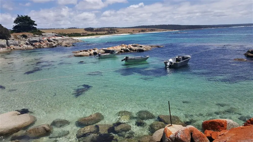 looking out from the shoreline to blue water and rocks