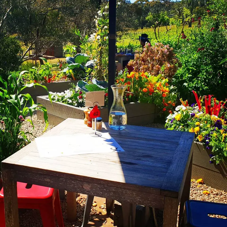 Mornington Peninsula day trip - an outdoor table with pretty flower beds in the background